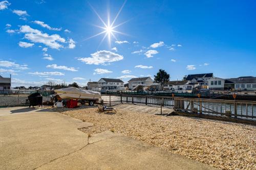 a sun shining over a body of water with houses at Canal-Front Home with Dock in Little Egg Harbor! in Little Egg Harbor Township
