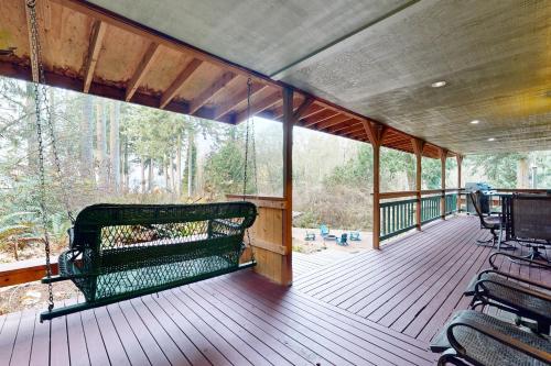 a screened in porch with a bench on the deck at Hawk's Hole in Hansville