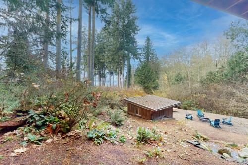 a small shed and two blue benches in a forest at Hawk's Hole in Hansville