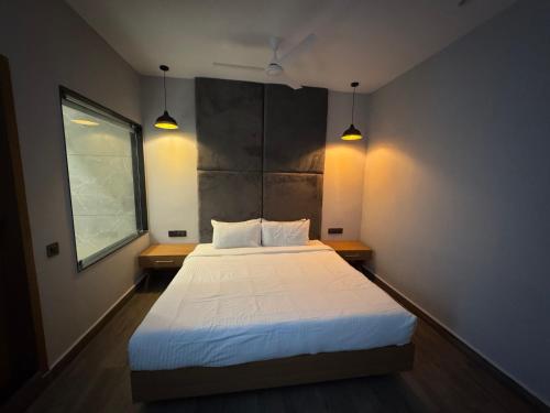 a bedroom with a large bed with two lamps at The Beach House Candolim in Candolim