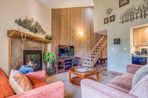 a living room with a fireplace and a staircase at Ski House 245 - Meredith Lodging in Bend