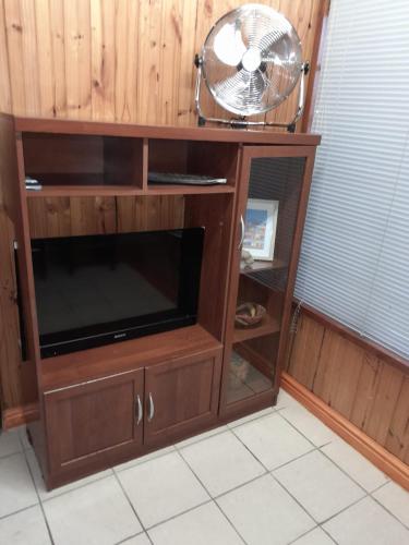a wooden entertainment center with a fan on top of it at Townhouse at Eagles Nest, Southport, KZN south coast in Port Shepstone