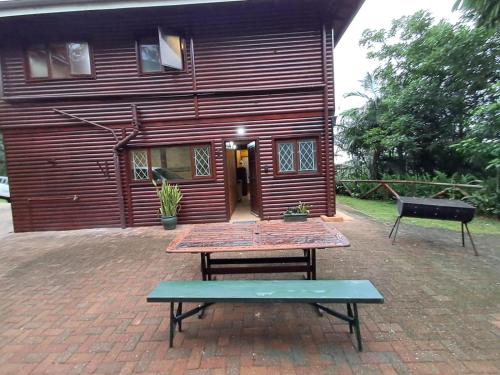 a picnic table in front of a red building at Townhouse at Eagles Nest, Southport, KZN south coast in Port Shepstone