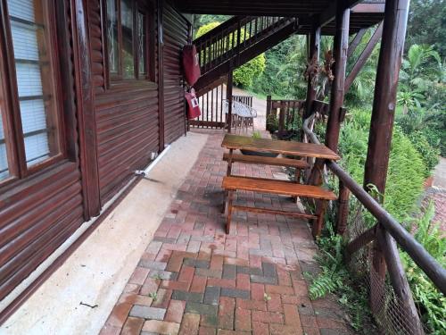 a wooden bench sitting on the porch of a house at Townhouse at Eagles Nest, Southport, KZN south coast in Port Shepstone