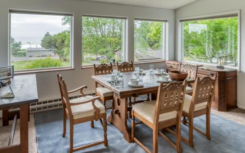 a dining room with a table and chairs and windows at The Boat House in Yachats