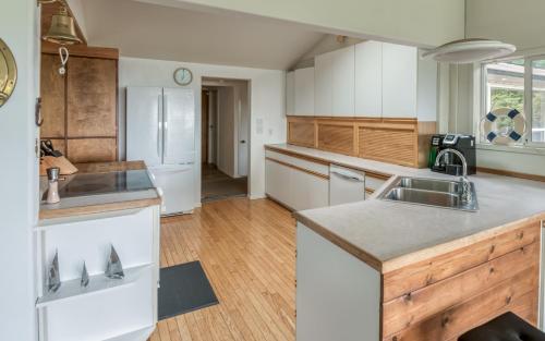 a kitchen with white cabinets and a sink at The Boat House in Yachats