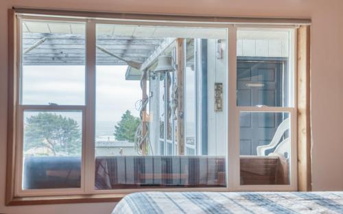 a bedroom with a large window and a bed at The Boat House in Yachats