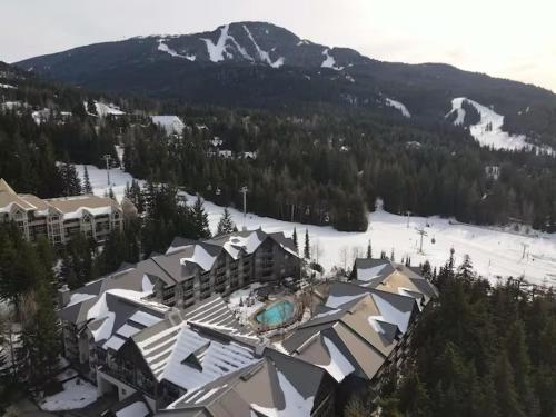 an aerial view of a resort with a snow covered mountain at Aspens by WB Vacation Rentals in Whistler