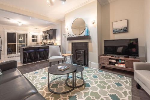 a living room with a couch and a tv and a fireplace at Blvd House Quidi Vidi Lake Parking in St. John's