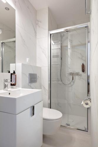 a white bathroom with a sink and a shower at Hotel Rzemieślnik Zakopane in Zakopane
