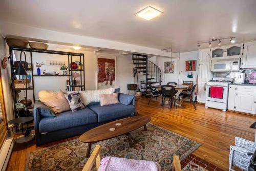 a living room with a blue couch and a table at Iconic Battery Cottage Signal Hill Sea&City Views in St. John's