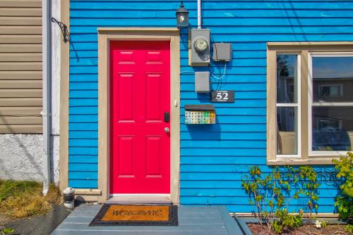 a red door on a blue house at Victoria Hilltop Jelly Bean 3 Bed Large Yard in St. John's