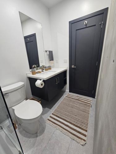 a bathroom with a toilet and a sink and a mirror at Villa Sea Breeze in West End