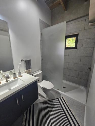a bathroom with a sink and a toilet and a mirror at Villa Sea Breeze in West End