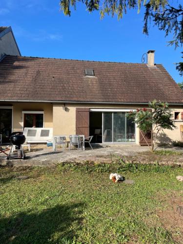 a dog laying in the grass in front of a house at Gîte pieds dans l Epte prêt de Giverny in Gasny