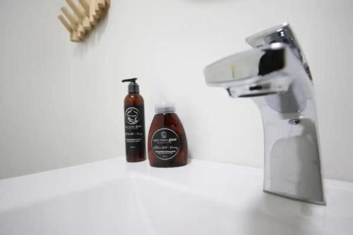 two bottles of hot sauce sitting on a counter next to a mixer at Queens Suite 1bdrm in St. John's