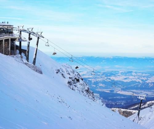 a ski lift on top of a snow covered mountain at Hotel Rzemieślnik Zakopane in Zakopane