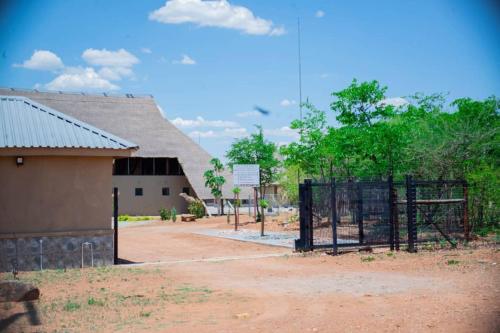 a fence in front of a building with a giraffe at Kuswani Hotel in Sebina