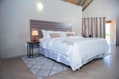 a large white bedroom with a large bed and a window at Kuswani Hotel in Sebina
