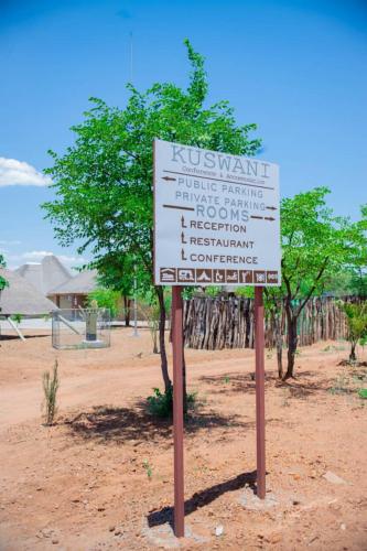 a sign in the middle of a field with trees at Kuswani Hotel in Sebina