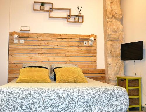 a bedroom with a bed with a wooden headboard at L'Oriflamme in Avignon