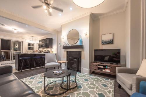 a living room with a couch and a tv at Blvd House Quidi Vidi Lake Parking in St. John's