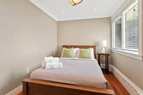 een slaapkamer met een groot bed met groene kussens bij Forest House Qv Lake View Parking in St. John's