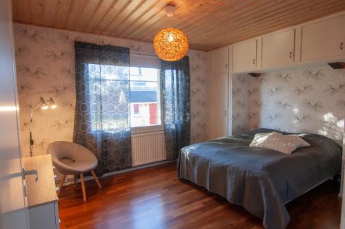 a bedroom with a bed and a chair and a window at Kent's Lodge in Herrefors