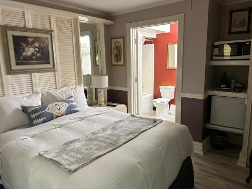 a bedroom with a large white bed and a bathroom at Arrowhead Lake Inn in Lake Arrowhead