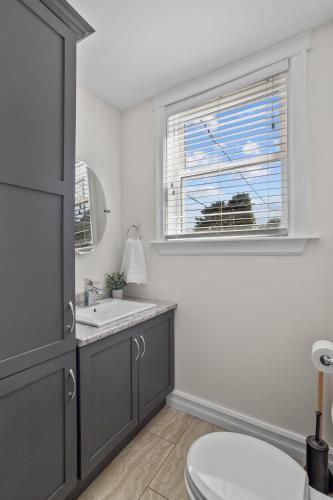 a bathroom with a toilet and a sink and a window at Victoria Hilltop Jelly Bean 3 Bed Large Yard in St. John's