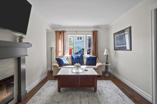 a living room with a couch and a fireplace at Victoria Hilltop Jelly Bean 3 Bed Large Yard in St. John's