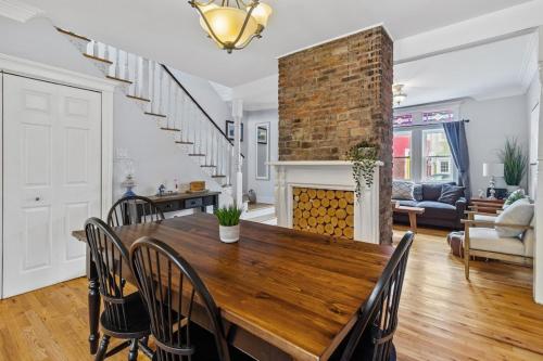 a dining room with a wooden table and a fireplace at Historic Jelly Bean Row House, Walk To Signal Hill in St. John's