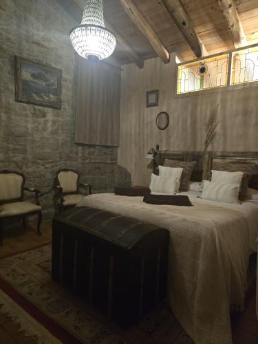 a bedroom with a large bed and a chandelier at El Racó dels Mussols 2 in Adri