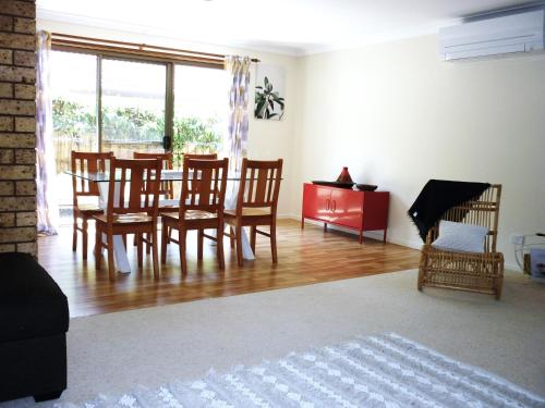 a living room with a dining room table and chairs at Two 46 Brodie in Coffs Harbour