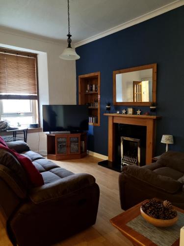 a living room with a couch and a television at Brucefield Avenue, Dunfermline in Dunfermline