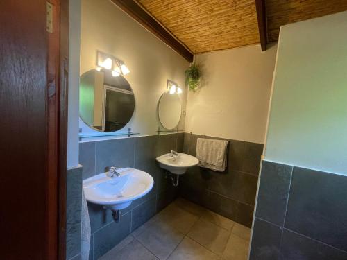 a bathroom with two sinks and two mirrors at Basco River Lodge Luxury Apartment in Grabouw
