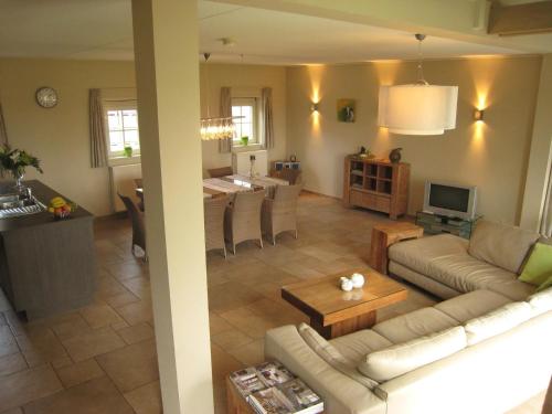 a living room with a couch and a table at Stylish Holiday Home in Zuidzande with Sauna in Zuidzande