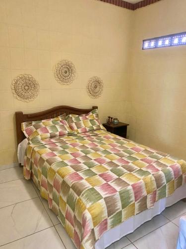 a bedroom with a bed with a colorful comforter at O De Casa in Japaratinga