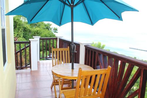 a table with a blue umbrella on a balcony at Buena Vista SLC in Vieux Fort