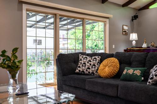a living room with a gray couch with pillows at Luxury Estate with Sparkling Pool & Elegant Amenities in Glendora