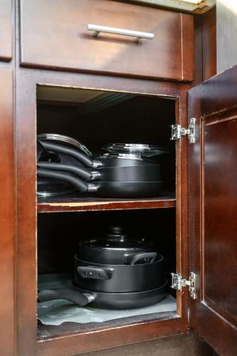 a cabinet with plates and pans in it at Luxury Estate with Sparkling Pool & Elegant Amenities in Glendora