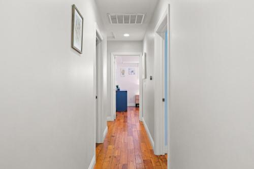 a hallway with white walls and a hardwood floor at Luxury Estate with Sparkling Pool & Elegant Amenities in Glendora