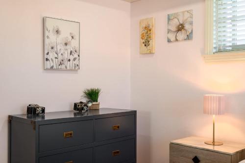 a bedroom with a dresser and a lamp on a table at Luxury Estate with Sparkling Pool & Elegant Amenities in Glendora