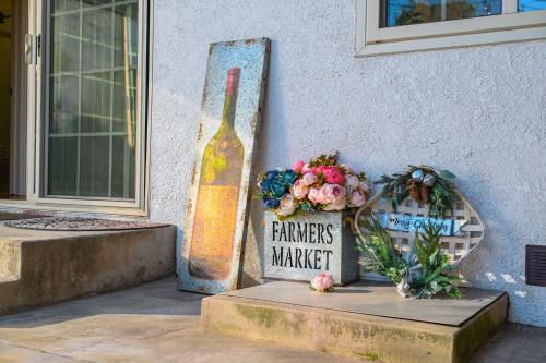 a statue of a wine bottle next to a table with flowers at Luxury Estate with Sparkling Pool & Elegant Amenities in Glendora