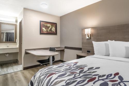 a hotel room with a bed and a desk at Red Roof Inn Greenville in Greenville
