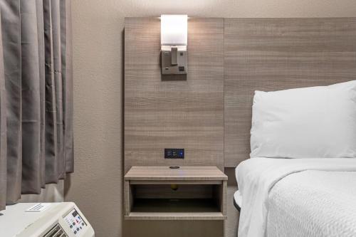 a hotel room with a bed and a nightstand next to a bed sidx sidx at Red Roof Inn Greenville in Greenville