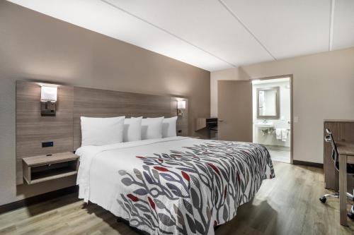 a hotel room with a large bed and a bathroom at Red Roof Inn Greenville in Greenville