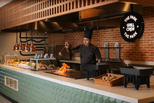 a chef standing in a kitchen preparing food at Grand Sirenis Riviera Maya Resort & Spa All Inclusive in Akumal
