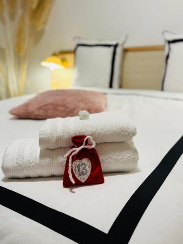 une pile de serviettes posée sur un lit dans l'établissement DAMA Lodge, à La Ferté-Bernard