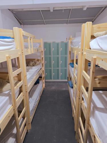 a room with four bunk beds and green lockers at Ô de casa hostel in Balneário Camboriú